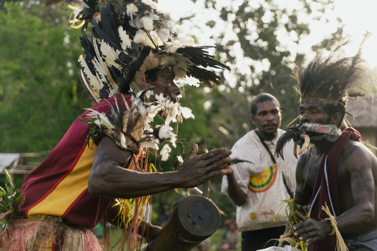 Community members dance whilst wearing ceremonial dress for a ceremony in Sololo, Papua New Guinea.